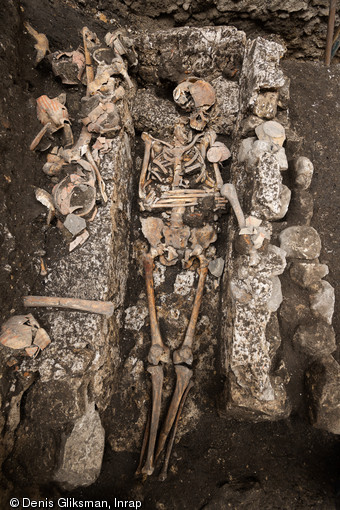 Sépulture du cloître du prieuré Saint-Éloi (XIIIe-XIVe s.), découverte sur le site de la préfecture de police de Paris, 2013. À droite, un vase à encens. 