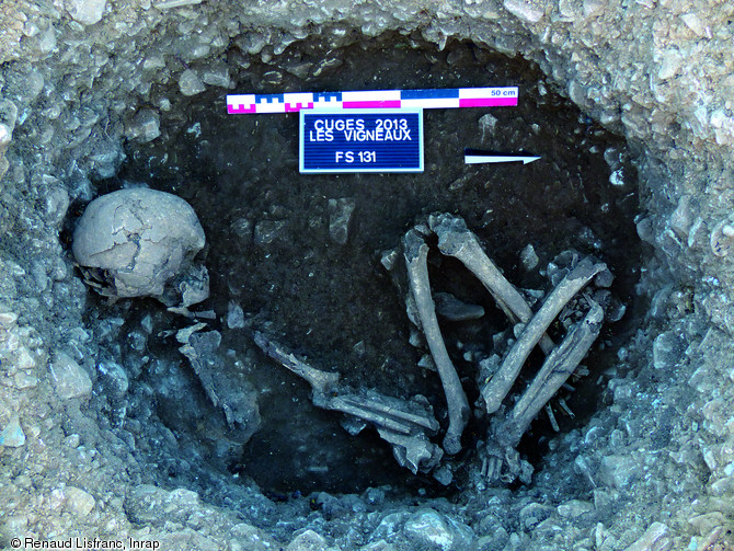 Tombe néolithique en fosse mise au jour sur la fouille de la ZAC des Vigneaux à Cuges-les-Pins (Bouches-du-Rhône) en 2013. Le squelette qui repose en appui sur son côté gauche dans une posture contractée témoigne du dépôt du corps du défunt et du comblement de la fosse (inhumation en pleine terre ).