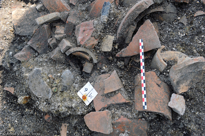 Agglomérat d’os humains brûlés avec une monnaie gauloise entouré de morceaux d’amphores et de vaisselle découverts dans la nécropole datée du tout début de l'époque romaine (30 avant notre ère). 