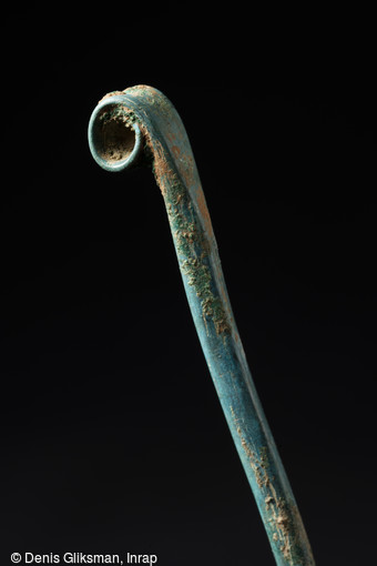 Épingle à tête enroulée, âge du Bronze final, 1200-800 avant notre ère, Obernai (Bas-Rhin), 2013.  Le site d'Obernai a livré des vestiges de plusieurs périodes, les plus anciens remontant au Néolithique, les plus récents à la fin de la période romaine. 