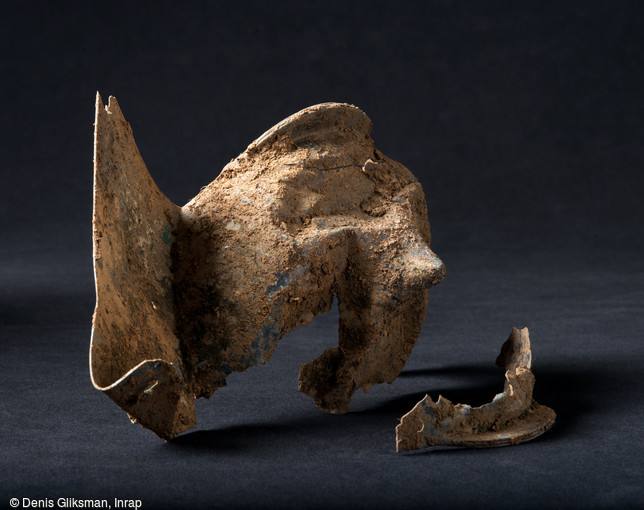 Umbo en bronze de l'époque gauloise, entre 150 et 30 avant notre ère, Obernai (Bas-Rhin), 2013.  L'objet semble avoir été volontairement brisé à coup d'épée. 