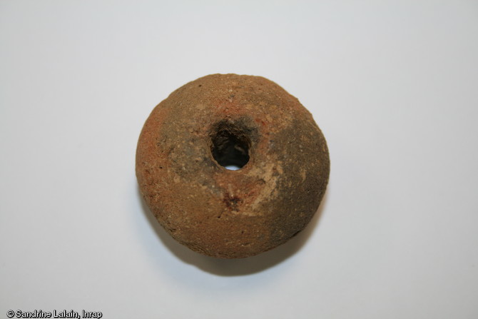 Fusaïole de l'âge du Bronze, vers 1000 avant notre ère, Caudan (Morbihan), 2013.Cet élément de terre cuite est utilisé pour les activités de filage.