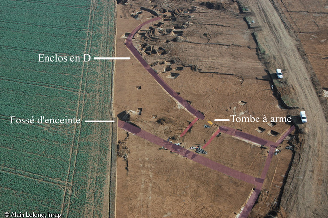 Vue aérienne du secteur nord de l'enclos en D, IVe-IIIe s. avant notre ère, Ymonville (Eure-et-Loir), 2010.Entre l'enclos et le fossé d'enceinte a été mise au jour une allée longue de 20 m et large de 10, dans laquelle a été découverte une tombe de guerrier antérieure à l'édification de l'enclos mais prise en compte au moment de sa construction.