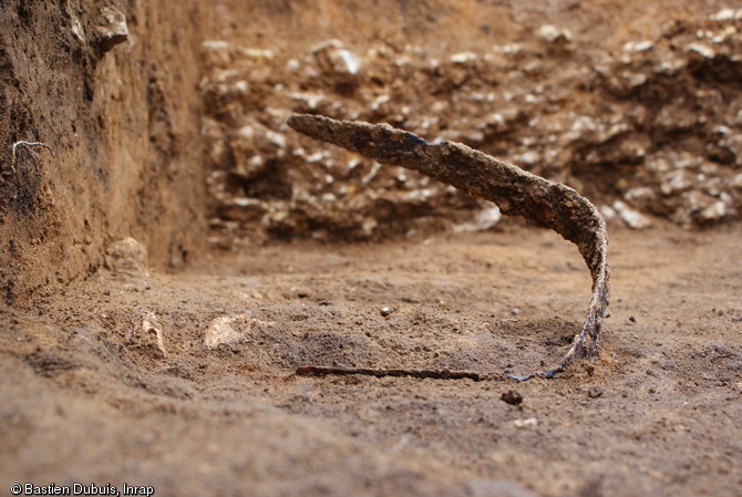 Épée ployée en cours de dégagemement, IIIe s. avant notre ère, Ymonville (Eure-et-Loir), 2010.Autour de la tombe de guerrier de nombreux dépôts, exclusivement guerriers, ont été découverts.     