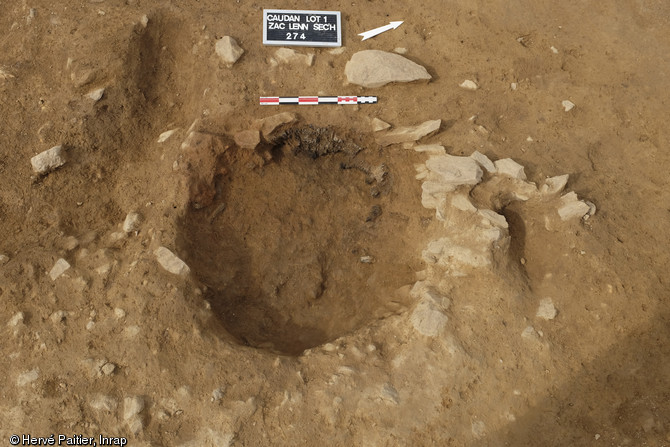 Traces d'un foyer situé à l'intérieur d'un bâtiment sur poteaux, vers 1000 avant notre ère, Caudan (Morbihan), 2013.On observe un aménagement empierré dans la partie nord.