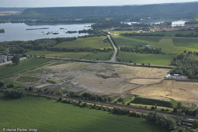 Vue aérienne du site du  Chemin du Bosquet  à Val-de-Reuil (Eure), 2012.L'opération a été menée sur 8 ha dans la zone de confluence Seine - Eure - Andelle, dans le cadre de l'extension d'une carrière de granulats. Le site a révélé d'importants vestiges couvrant une large période, depuis l'âge du Bronze jusqu'au Moyen Âge.