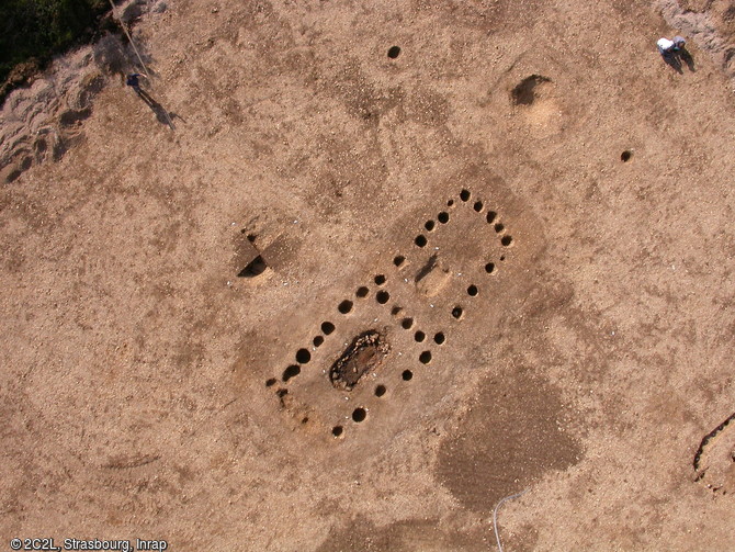 Vue zénithale d'un bâtiment néolithique abritant une sépulture collective, Passy-Véron (Yonne), 2006. L'édifice mesure 11,5 m de long sur 3,5 à 4 m de large. Une rangée de quatre poteaux sépare l'espace intérieur. À l'intérieur de la sépulture, ont été enterré au moins 41 individus. 