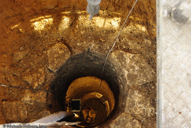 Fouille au fonds d'un puits antique à Entrains-sur-Nohain (Nièvre), 2013.  À plus de quatre mètres de profondeur, dans un espace d'un diamètre d'environ 1,3 m, les archéologues mettent au jour les ossements d'individus victimes d'un massacre ou d'une épidémie à dater entre les VIIIe et Xe s.  