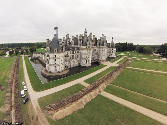 Vue générale du château de Chambord (Loir-et-Cher) et du parterre prise depuis le nord-est en regardant vers le sud-ouest, 2013.A droite, on voit le premier sondage qui recoupe le parterre nord, parallèle à la façade principale du château. Il a permis de retrouver les traces du Petit Jardin devant la tour de la Chapelle, figuré sur les plans du site au début des premiers travaux sous Louis XIV, entre 1680 et 1686, mais dont l'origine est sans doute plus ancienne.