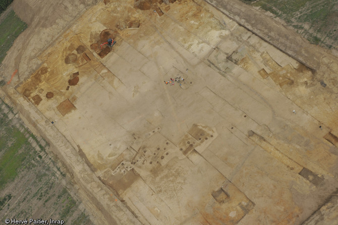 Vue aérienne du site de Touzeau à Aigné (Sarthe), 2012.Les points sombres correspondent à des bas-fourneaux utilisés pour réduire le minerai de fer. On en compte près de 90 sur le site.