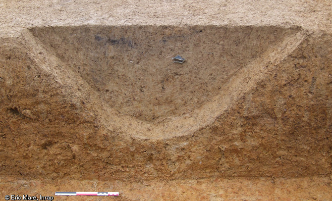 Coupe réalisée dans un fossé délimitant un enclos qui abrite un petit établissement agricole gallo-romain, Ier-IIe s. de notre ère, Auvers-le-Hamon (Sarthe), 2013.L'établissement s'inscrit à l'époque dans un paysage organisé par un vaste réseau parcellaire orthonormé.