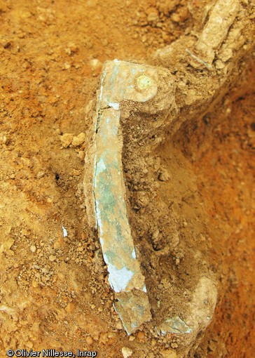 Bouterolle du fourreau, alliage à base de cuivre, dépôt d'armes de la fin du IVe - début du Ve s. de notre ère, Fontenay-sur-Vègre (Sarthe), 2012.