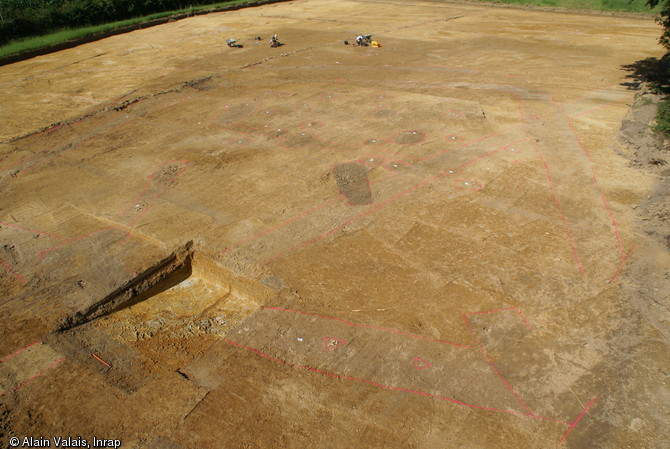 Vue générale du site des Touches à Juigné-sur-Sarthe (Sarthe), 2012.À un carrefour de chemins anciens, la fouille a révélé les vestiges d'un habitat monumental en bois des XIIIe-XIVe s. L'emplacement du fossé entourant l'enclos et les trous de poteaux sont entourés en rouge.