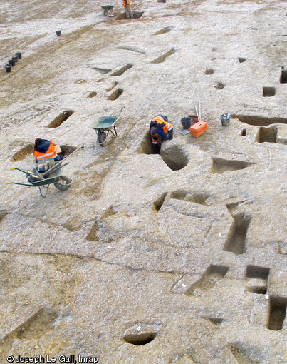 Fouille des bâtiments de la ferme gauloise de la Claraiserie, IIe s. avant notre ère - Ier s. de notre ère, Ossé (Ille-et-Vilaine), 2013.Les vestiges de ces bâtiments se matérialisent sur le terrain par les fosses ayant servi au calage des poteaux.