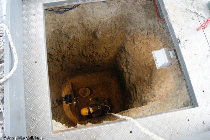 Fouille au fond d'une citerne découverte à la Claraiserie, IIe s. avant notre ère - Ier s. de notre ère, Ossé (Ille-et-Vilaine), 2013.De plan carré, la citerne présente une profondeur de 4 m. Un cuvelage en bois devait être aménagé sur sa paroi intérieure.