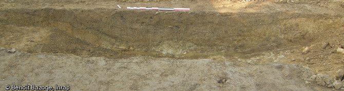 Vue en coupe d'un chemin creux repéré sur le site des Chauvières à La Quinte (Sarthe), 2012.La fouille a mis en évidence un habitat rural occupé entre les Xe et XIVe s., situé à 400 m de l'ancienne voie romaine reliant Le Mans à Jublains.