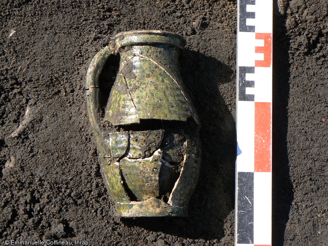 Pichet en céramique glaçurée retrouvé dans le comblement de l'enclos abritant un établissement agricole médiéval, XIIIe-XIVe s., Saint-Corneille (Sarthe), 2011.Il constitue une des nombreuses formes céramiques de l'époque médiévale recensées sur le site.