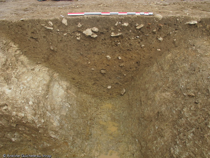 Coupe réalisée dans le premier fossé entourant le sanctuaire au Ier s. de notre ère, La Grillère, Saint-Denis-du-Maine (Mayenne), 2012.Cette enceinte fossoyée, taillée dans le schiste, forme un carré de 54 m de côté.