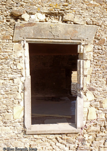 Fenêtre et cheminée de la salle à l’étage du manoir de Vassé à Torcé (Ille-et-Vilaine), 2013.Les deux éléments sont chaînées aux murs et sont donc contemporains de la construction du manoir. Or, le style des modénatures les rapproche de la deuxième moitié du XVe siècle. Fenêtre et cheminée ont été récupérées pour être intégrées à la construction du manoir de Vassé en 1520.