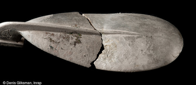 Vue de détail de l'inscription runique relevée sur l'extérieur de la cuillère en argent mise au jour dans une tombe de la nécropole de Niederfeld, fin du VIe s., Ichtratzheim (Bas-Rhin), 2011.L'inscription mentionne le nom abuda, peut-être le nom de la personne inhumée dans la tombe et propriétaire de l'objet.