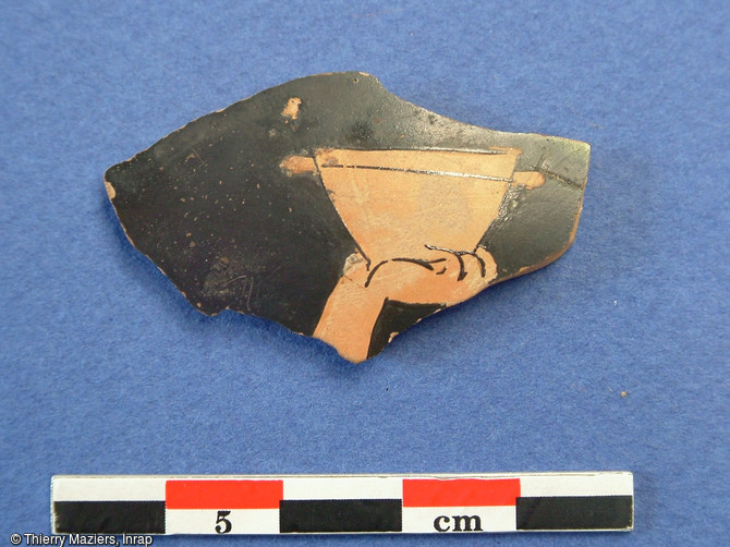 Fragment de vase attique à figures rouges, fouille du collège Vieux-Port, Marseille, 2005.Découvert en contrebas de la butte Saint-Laurent, ce tesson daté du début du Ve s. avant notre ère représente une scène de banquet dans laquelle un convive lève sa coupe emplie de vin.