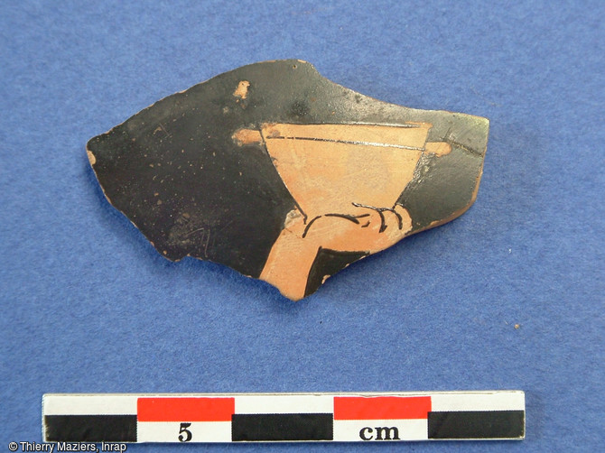 Fragment de vase attique à figures rouges, fouille du collège Vieux-Port, Marseille, 2005.Découvert en contrebas de la butte Saint-Laurent, ce tesson daté du début du Ve s. avant notre ère représente une scène de banquet dans laquelle un convive lève sa coupe emplie de vin.   