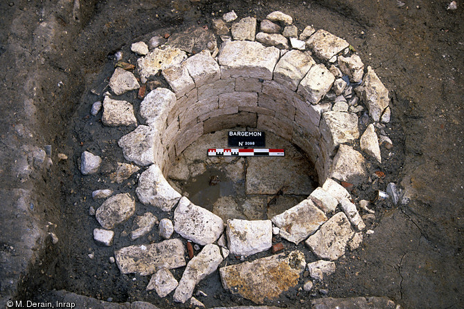 Puits médiéval en calcaire blanc, place Villeneuve-Bargemon, Marseille.Il est rare de pouvoir observer le dallage au fond des puits. C'est la proximité de la nappe phréatique qui a limité la profondeur de celui-ci.  Photo publiée dans l'ouvrage Quand les archéologues redécouvrent Marseille, M. Bouiron, P. Mellinand.