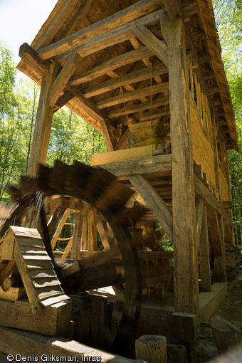 La roue hydraulique en action, moulin de Guédelon (Yonne), 2014.Cette roue à aubes mesure 2,40 m de diamètre et entraîne une meule de près de 1 m de diamètre et d’environ 250 kg.  