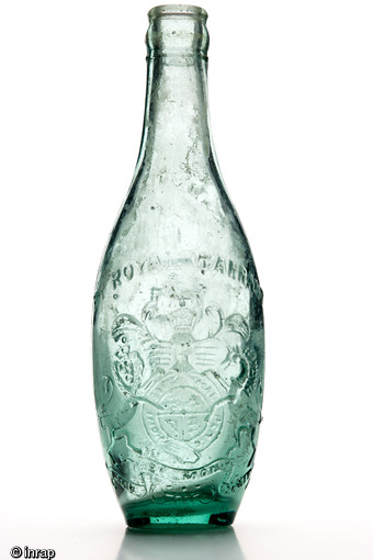Bouteille britannique ayant contenu une limonade au gingembre, utilisée lors de la bataille d’Arras de 1917 pendant la Première Guerre Mondiale et découverte en 2002 à Saint-Laurent-Blangy, (Pas-de-Calais). Le blason précise que la marque, Idris, est fournisseur officiel de la couronne. 