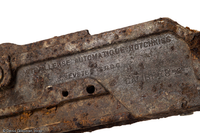 Détail de la mitrailleuse française de la marque Hotchkiss en acier usiné,  de calibre 8mm Lebel, découverte dans une tranchée de la Grande Guerre à Amiens (Somme), 2011.  Le marquage indique le nom du fabricant et du calibre. 
