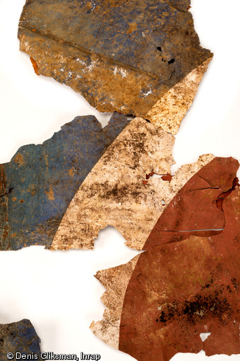 Fragments d'une cocarde britannique (composée de l'extérieur vers l'intérieur de bleu, blanc, rouge et cerclée de jaune) qui se situait sur le fuselage d'un planeur Horsa. Elle diffère de celles des ailes par la présence du liseré jaune. Datant du jour J de la Bataille de Normandie (nuit du 5 au 6 juin 1944) et découverts dans un trou d'homme à Ranville (Calvados), 2009. 