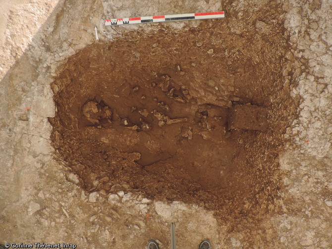 Vue de la sépulture 24-5 avec ses armatures tranchantes associées (au niveau du bassin), recoupant le fossé de fermeture oriental du monument. Nécropole du Néolithique moyen à Fleury-sur-Orne (Calvados), 2014.