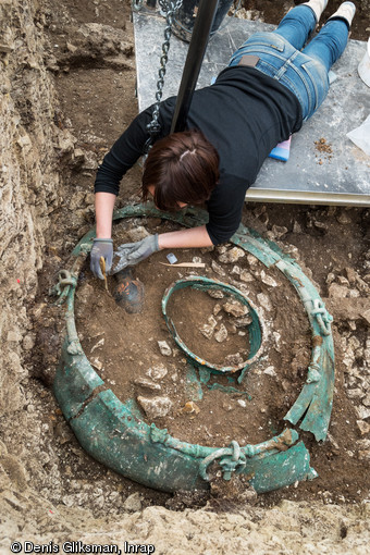 Fouille d'un chaudron en bronze d'un mètre de diamètre provenant d'une tombe princière datée du début du Ve siècle avant notre ère, retrouvée dans un complexe funéraire monumental exceptionnel, mis au jour à Lavau (Aube).