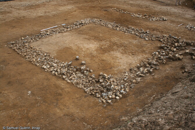 Fondations de la cella romaine du fanum (Ier s. de notre ère) constituées d'un radier de silex, à Estrées-Saint-Denis (Oise), 2014.  La cella abritait la représentation de la divinité et était réservée exclusivement aux religieux. Toutefois les fidèles pouvaient déambulaient dans la galerie qui l'entoure.  